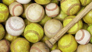 Baseballs and softballs with a bat for the Futures of Softball/Baseball Showcase