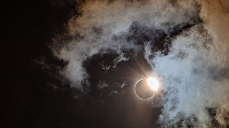 Sunlight streams from behind the moon during 99.7% totality