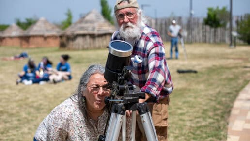 Phil Clark shares his telescope with Loretta Robinson during the eclipse