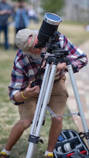 Phil Clark uses his telescope to watch the eclipse