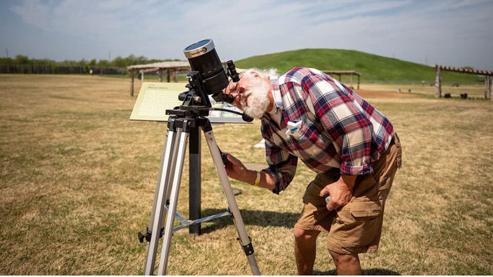 Phil Clark uses his telescope to watch the eclipse