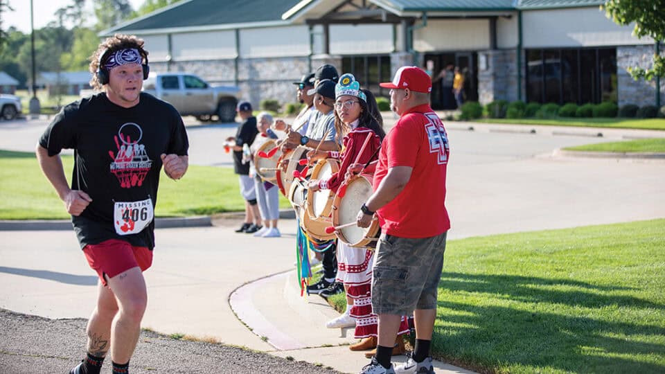 William Killman from Moyers, Oklahoma, finishes the 5K while the drummers welcome him across the finish line