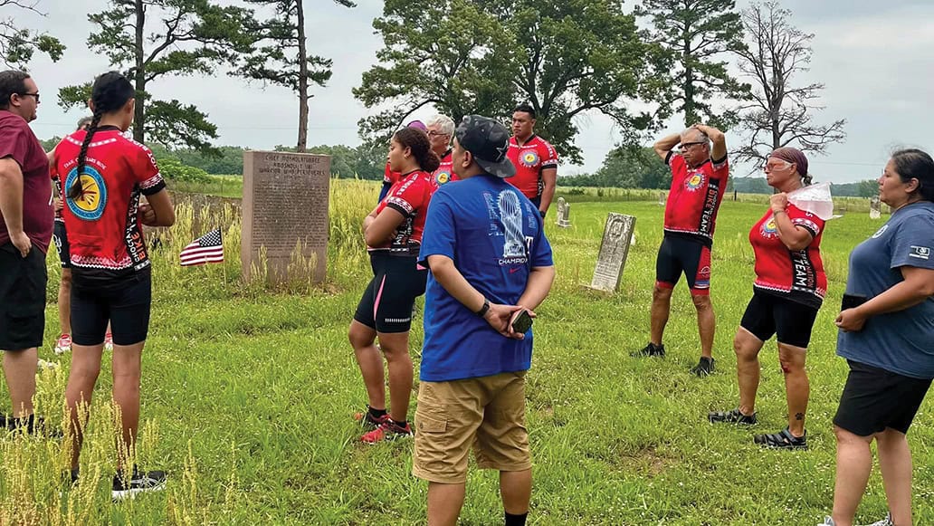 Trail of Tears Bike Team members listen as Ryan Spring gives a history lesson about Chief Moshulatubbee