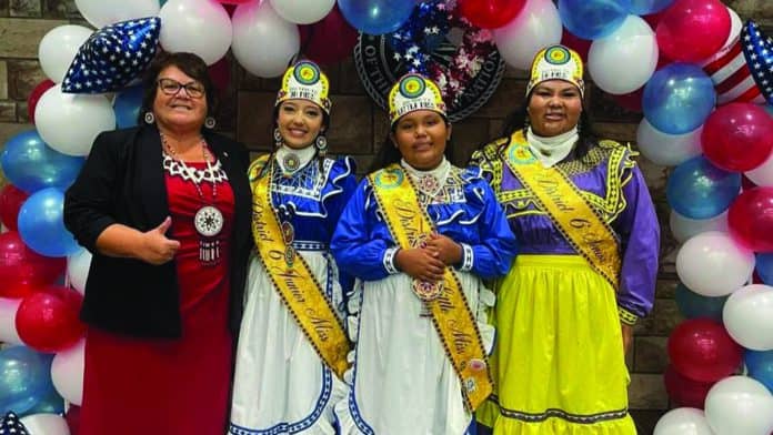 Councilwoman Jennifer Woods poses for a photo with three princesses dressed in traditional Choctaw Dresses and crowns.