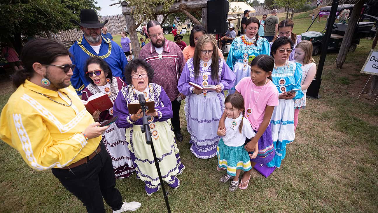 Group of Choctaw singers dressed in traditional Choctaw clothing sing in the Choctaw Village.