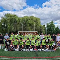 A lacrosse team dressed in lime green jerseys pose for a group photo.