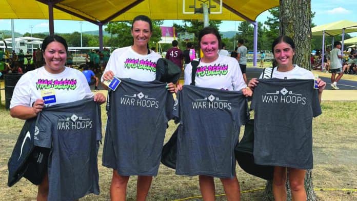 Four women pose with t-shirts.