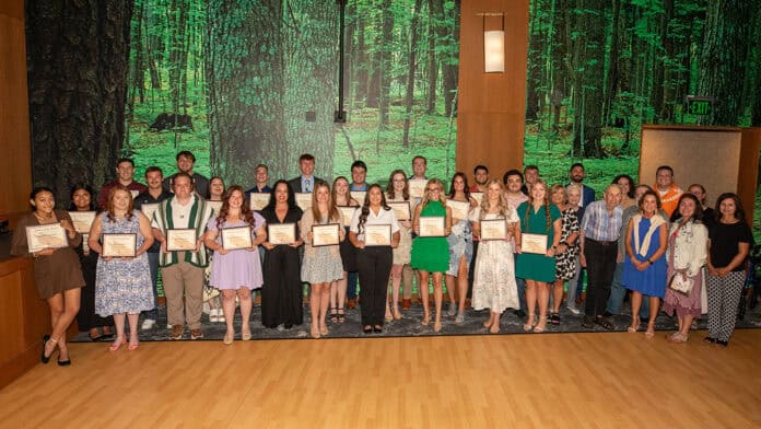 A large group of college students pose, holding their Chahta Foundation scholarship awards.