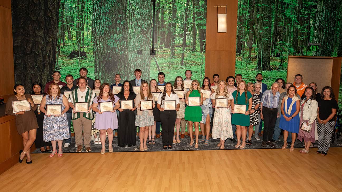 A large group of college students pose, holding their Chahta Foundation scholarship awards.