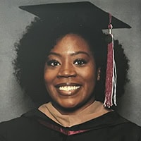 Yasmin Hamilton smiles for a photo with a cap and gown on