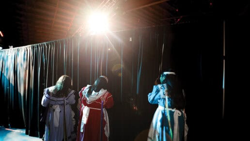 Princess contestants peek through the stage curtains.