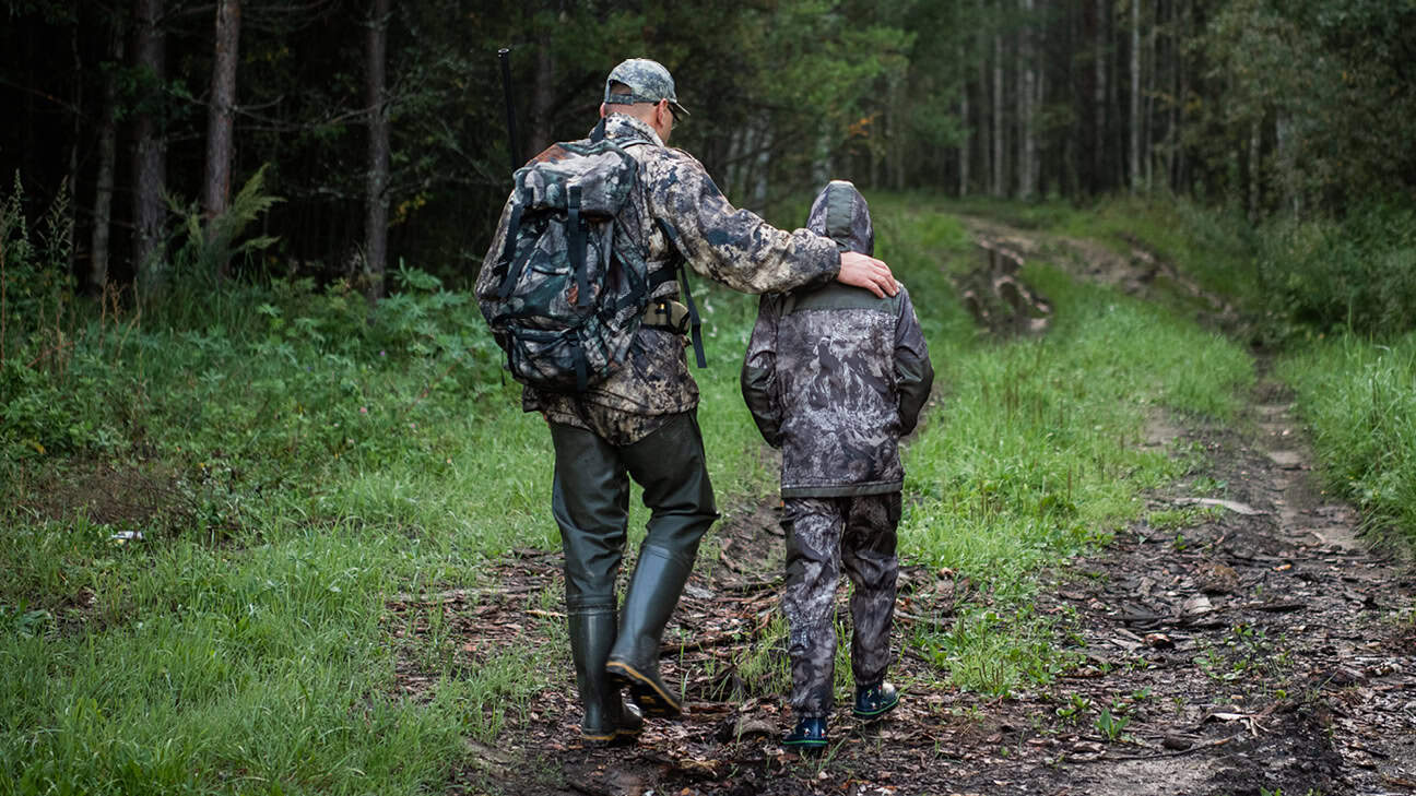 Dad and son walking while hunting and fishing