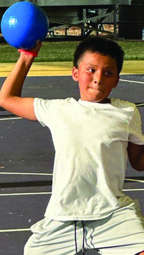 A boy throws a dodge ball.