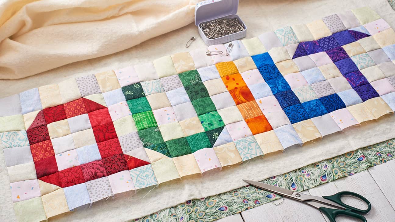 The word quilt sewn from colorful square and triangle pieces of fabric