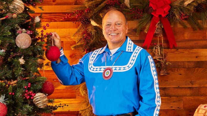 Chief Batton standing next to a decorated Christmas tree