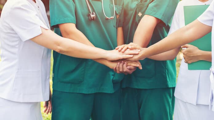 Nurses putting their hands together showing solidarity and support.