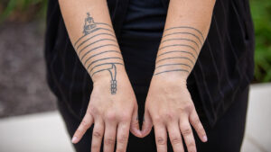 Traditional tattoos can be seen on a woman's arms.