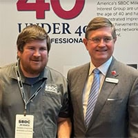 Two men pose for a photo.