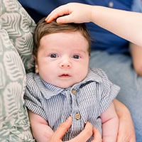 Miles Curtis, a young baby is held for a photo.