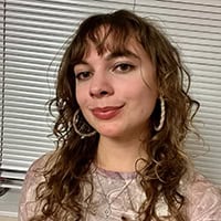 Young woman with curly dark hair.