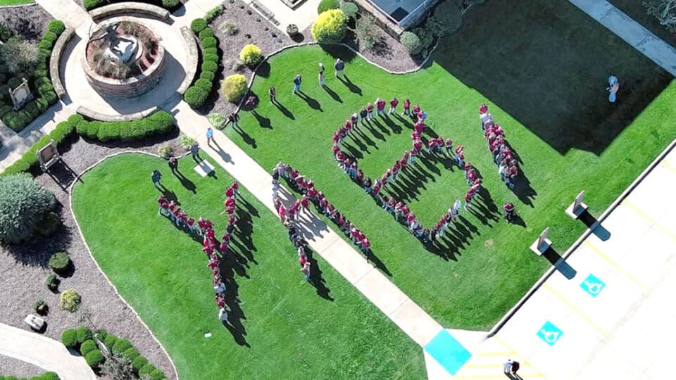 The letters YAB are spelled out by students in an aerial view.