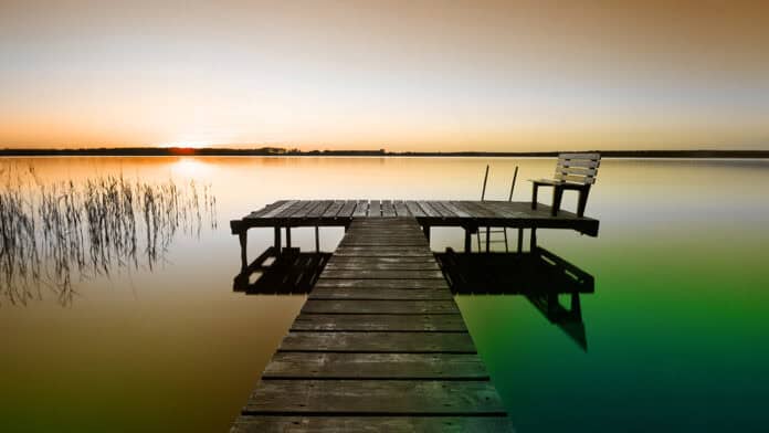 Dock overlooking lake in Choctaw Nation with a sunset on the horizon