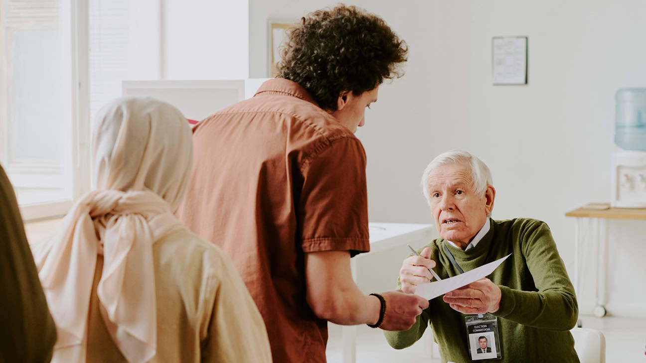 Voting official helping people with their ballot