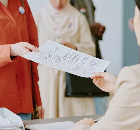 Voter handing over their voter ballot