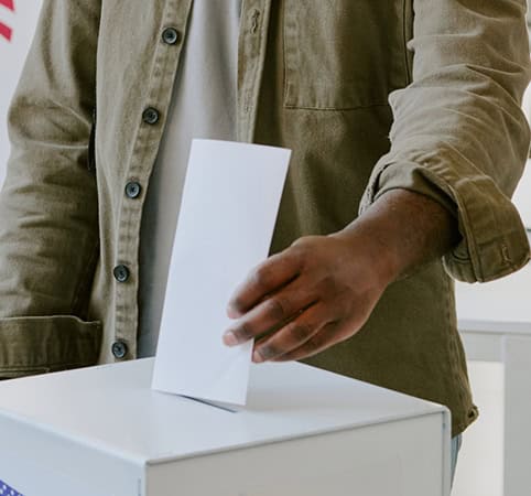 Voter putting ballot in box