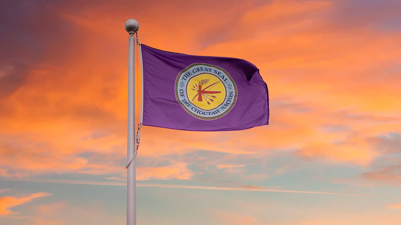 Choctaw flag flying under a sunset sky